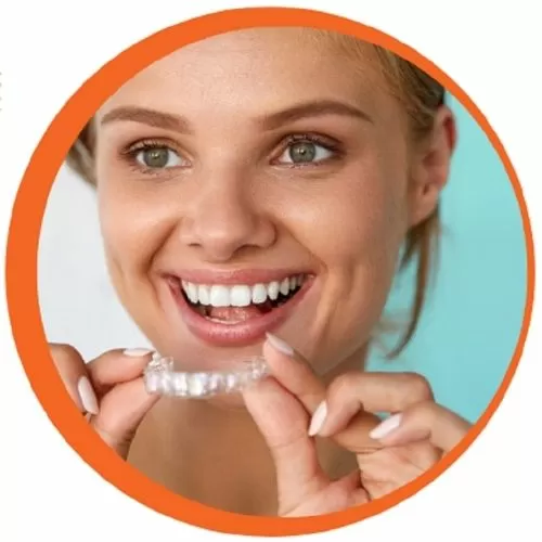 Smiling girl putting on retainer